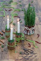 Festive candle holders and centrepiece made from cinnamon sticks, rosemary, dried chillis and ribbon. 