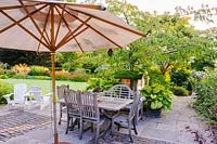 Wooden dining table and parasol on terrace, Newport, Wales