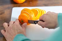 Slicing oranges on kitchen worktop