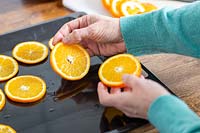 Placing slices of orange onto oven tray