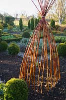 Colourful willow stems used to make a wigwam in the potager at Barnsley House, Cirencester, UK