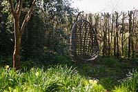 Hanging chairs in the woodland garden. Barnsley House, Cirencester, Glos, UK. 