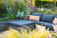 Seating area surrounded by raised beds. The RNIB Community Garden. Designers: Steve Dimmock, Paula Holland, RHS Hampton Court Palace Flower Show, 2018.