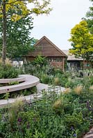 Stone terraced seating next to borders full of perennials and grasses - The RHS Feel Good Garden, RHS Chelsea Flower Show 2018