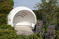 The CHERUB HIV garden: A Life Without Walls Garden - modern white garden pod shelter with bench seating area, Acer trees and dwarf pinus - Sponsor: CHERUB - RHS Chelsea Flower Show 2018