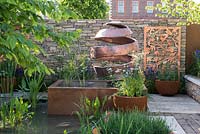 Raised infinity-edged water feature with twisted 'Citrus Peel' sculpture - The Silent Pool Gin Garden - Sponsor: Silent Pool Distillers - RHS Chelsea Flower Show 2018