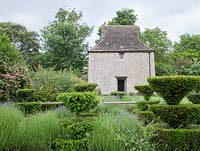 Looking across topiary to early 16th-century dovecot in reconstructed Medieval Garden The Prebendal Manor