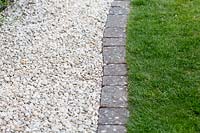 Gravel path with stone sett edging and lawn Pam Woodall's garden, 'Pinecombe' in Dorset, UK