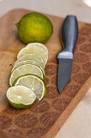 Lime sliced on chopping board with knife