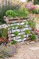 Recycled herb garden - Pallet planter with painted heart shape, herbs in tin cans