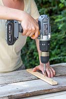 Fixing together two long boards with small cross timbers using electric screwdriver