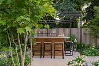 Outdoor bar with pergola, Acer cappadocicum in foreground - The Landform Garden Bar, RHS Hampton Court Palace Flower Show 2018
