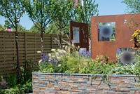 Fence with row of Prunus serrula, raised bed with tile feature and steel decorative panels by Steel Project Management - RNIB's Community Garden, RHS Hampton Court Palace Flower Show 2018