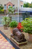 Front garden with tiled path and lion statue. The Secret Garden at Serles House, Wimborne, Dorset, UK