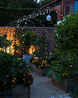 Pretty night lighting hung on a metal tunnel in the potager area.