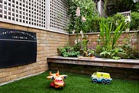 Family friendly garden with childrens toys, built in bench and blackboard