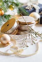 Gold painted foliage with spools of ribbon and baubles