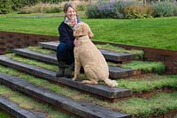 Liz Goodrich on the oak and woven metal steps with Mister the Labradoodle. 