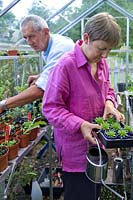 Freda and Barry Waldapfel tending plants in the greenhouse. 