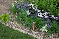 Mixed planting in gravel border. Southend Council 'By The Sea' garden at RHS Hampton Court Flower Show, London, 2017.