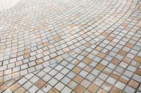 Contemporary paved area of stone setts, a circular pattern and straight