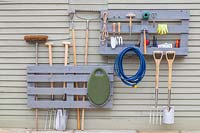 Pallet storage organiser - split painted pallet used for storing tools and gardening equipment. 