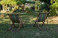 Deck chairs on lawn with view of garden beyond