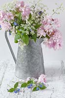 Spring cut flowers in metal rustic jug. 