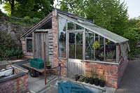 Outside of a combined greenhouse and shed showing two entrances
