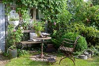 Seating area made from vintage collectables in cottage garden setting
