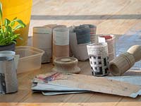 Equipment ready to make small pots from old newspapers, note wooden mould and sheets of newspaper cut to size
