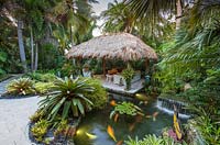 The chickee hut and pond in tropical garden. The Jones Residence, Key West, Florida, USA. Garden design by Craig Reynolds.


