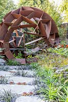 Corten steel sphere by William Roobrouck near foliage in 'Elements Mystique Garden', 
sponsored by Elements Garden Design 
