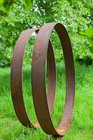 Moongates - circles of mild steel - set in grass with trees beyond
