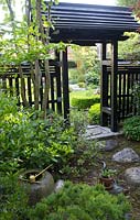 Stepping stone path to gate in Japanese themed garden