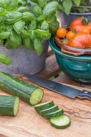 Harvested Cucumber 'Burpless Tasty Green' sliced on chopping board