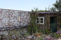Shell wall, rocks, hut and coastal planting.  Rias de Galicia: A Garden at the End of the Earth. Designed by Rose McMonigall, sponsored by Turismo de Galicia. RHS Hampton Court Flower Show, 2018.
