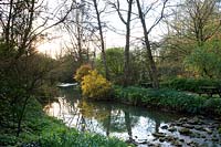 View of River Avon and surrounding woodland planting at Abbey House Gardens, Malmesbury, UK. 