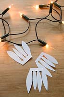 With scissors, cut a freehand shape with four petals, to attach to fairy lights.