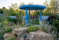 Rainfall pavilion with raincatchers, gravel garden with Agave americana, Lychnis coronaria 'Alba' and Santolina chamaecyparissus. RHS Hampton Court Palace Flower Festival 2019.