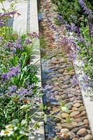 Pebble filled water rill with soft planting. RHS Hampton Court Palace Flower Festival 2019.