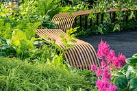 Contemporary curved, slatted wooden benches at the RHS Hampton Court Palace Garden Festival 2019. Sponsor: Smart Energy GB.