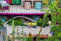 The childrens garden with lots of colurful planting and play equipment in the Montessori Centenary Children's Garden at RHS Chelsea Flower Show 2019