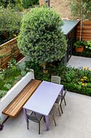 Overview of small contemporary London garden with furniture and raised beds 