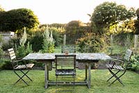 Lichen encrusted table and chairs at the centre of the vegetable garden at Sea View, Cornwall in June