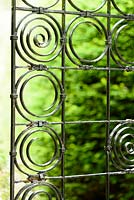 Elegant wrought iron gate of squares and circles at York Gate garden, Adel in July.