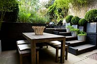 View from dining area with steps up to a multi-level urban garden
