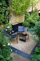 Private seating area in sheltered modern garden