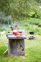 Rustic wooden table and chairs, table set for breakfast - fire place with cooking facilities in background