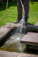 Topping up a water feature using a hosepipe